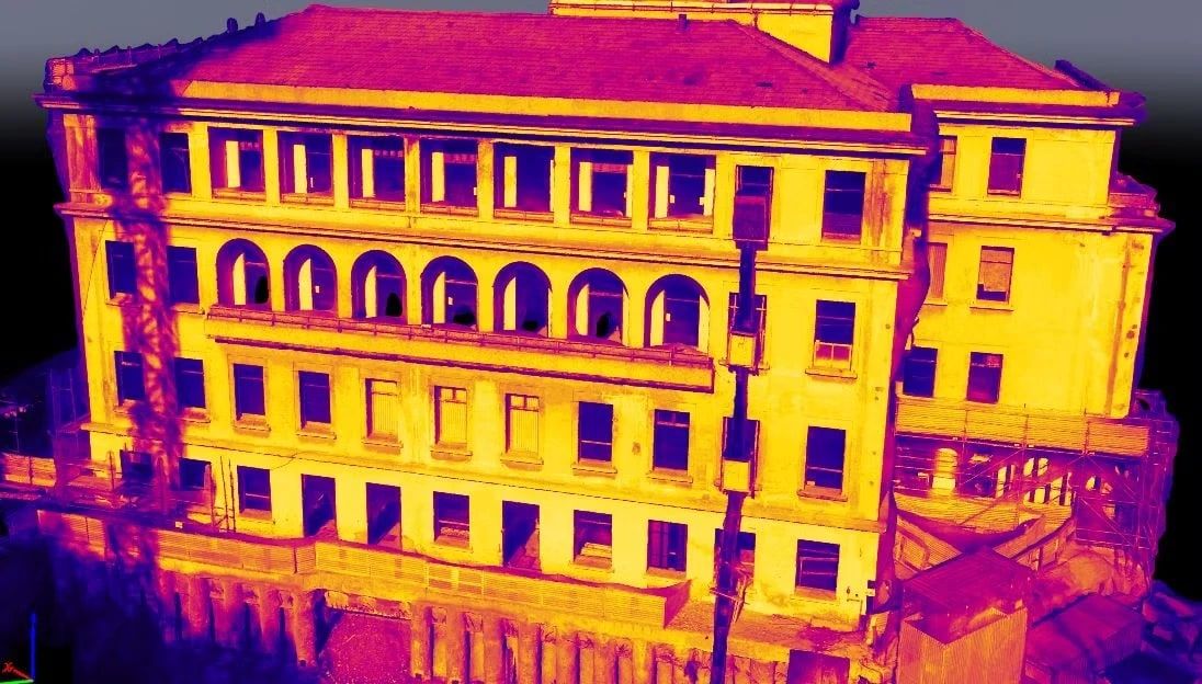 Imagem térmica de um prédio de quatro andares com arcos na fachada, em tons de amarelo, laranja e roxo conforme a temperatura